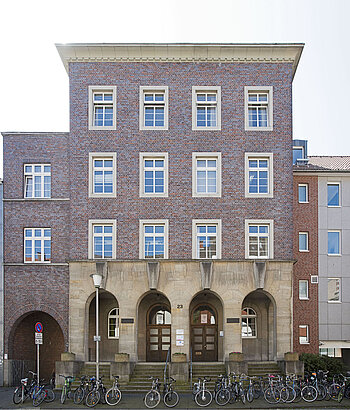 Heutiges Foto des deutschen Studentenheimes in Münster. Ein vierstöckiges Gebäude mit Klinkerfassade und einem Eingang aus Sandstein.